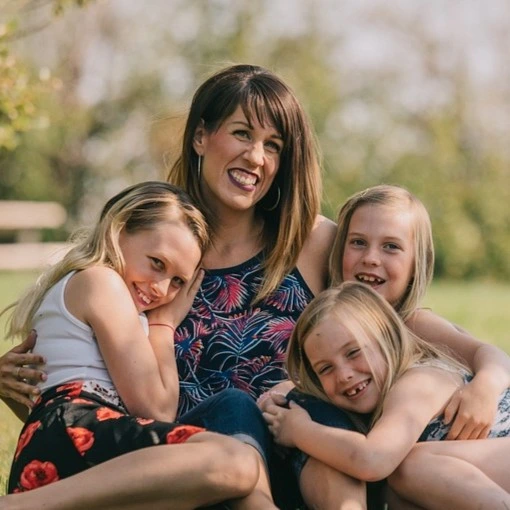 Lächelnde Mutter mit 3 Kindern. Kinder im Alter von 8 bis 12 Jahren. Alle mit fröhlichem Gesichtsausdruck.