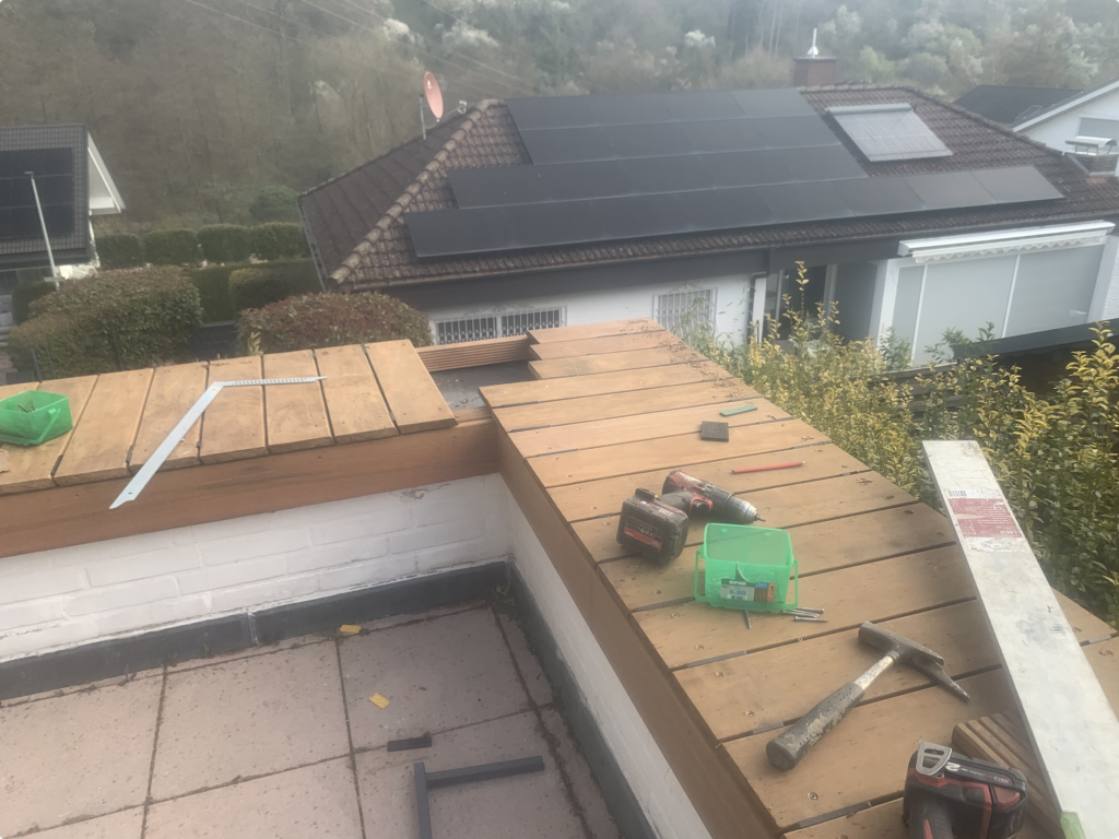 Vorbereitung der Eckausbildung einer Ipe Holzabdeckung auf bestehenden Pflanzkästen auf einer Terrasse in Bad Soden