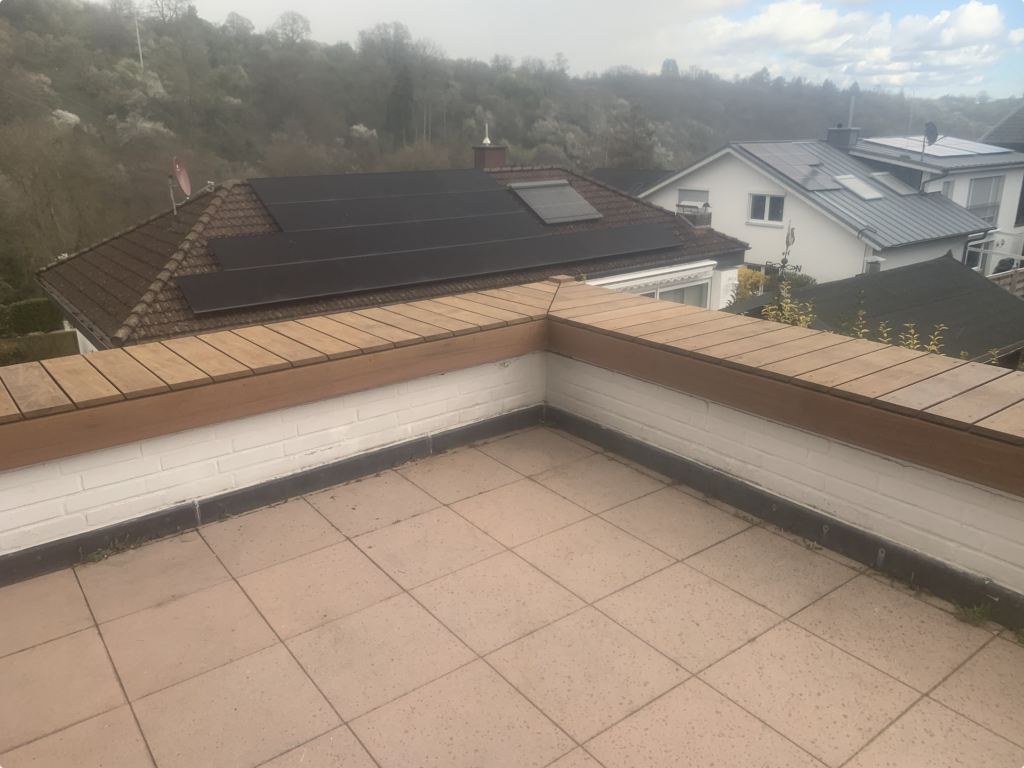 Fertig ausgeführte Eckausbildung einer Ipe Holzabdeckung auf bestehenden Pflanzkästen als Sitzkante auf einer Terrasse in Bad Soden