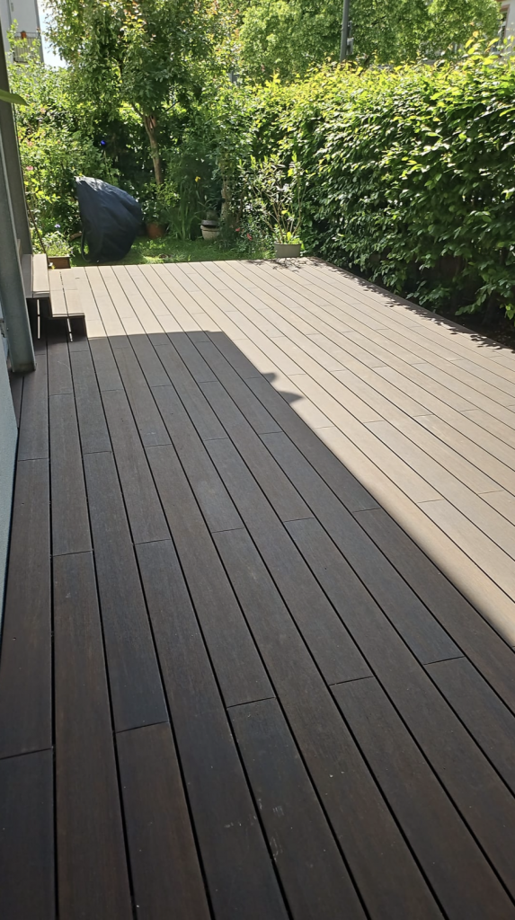 Fertiggestellte Bambusterrasse in Frankfurt-Bornheim mit großzügiger Fläche, dunklen Bambusdielen und harmonischem Übergang zum Garten. Die Terrasse bietet deutlich mehr Nutzfläche als die ursprüngliche Konstruktion.