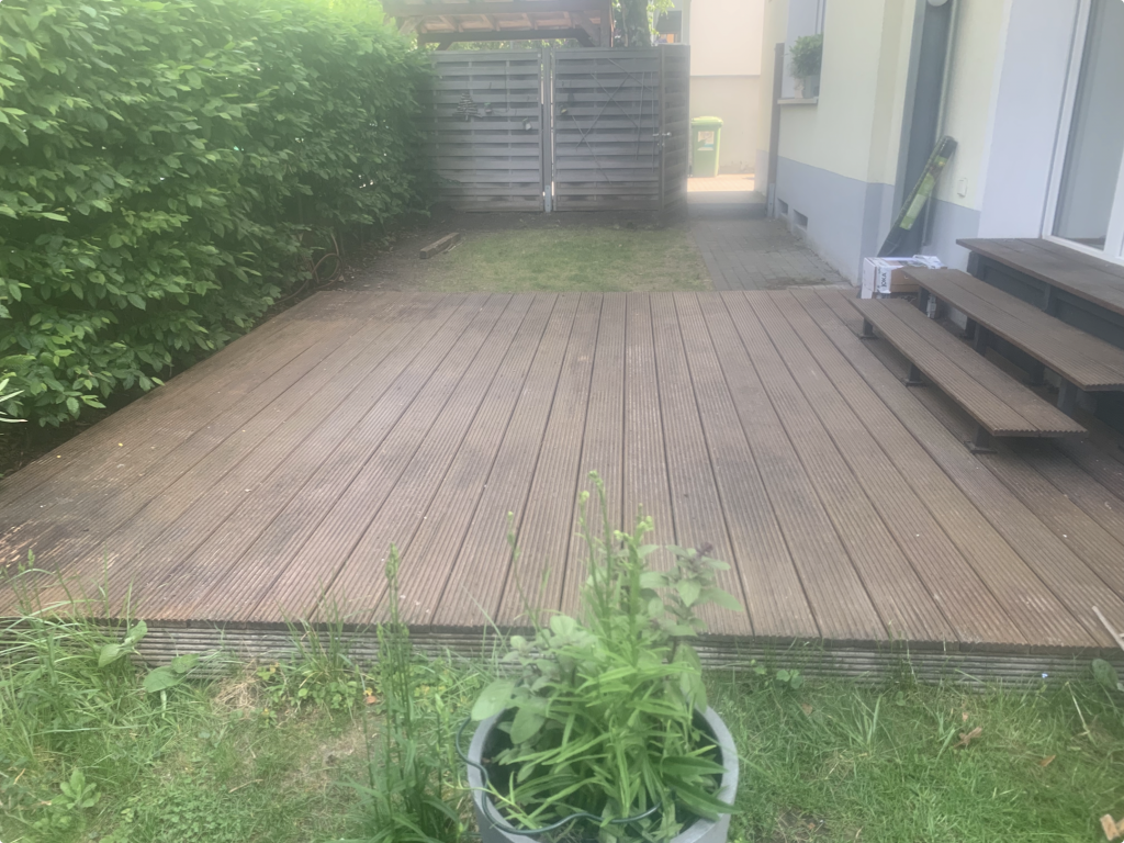 Alte Bangkirai-Terrasse vor der Sanierung in Frankfurt-Bornheim mit Holzstufen, gealterten Terrassendielen und angrenzendem Gartenbereich als Ausgangssituation für den Terrassenneubau.