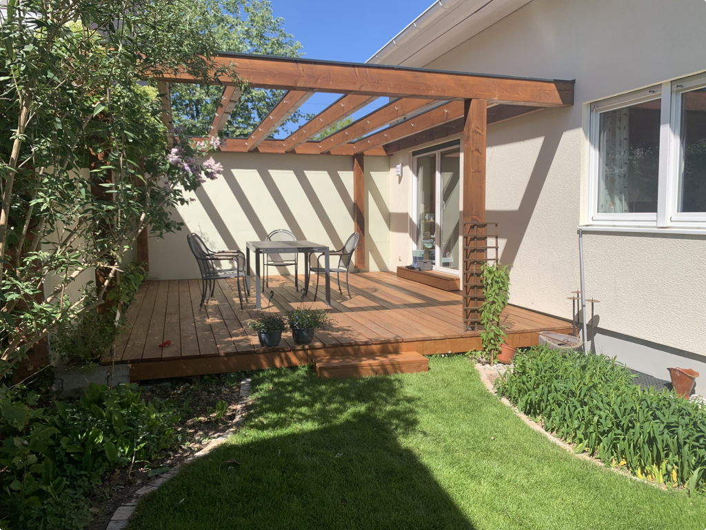 Fertiggestellte Garapa Holzterrasse mit moderner Pergola und Sitzbereich in einem Garten in Frankfurt-Fechenheim