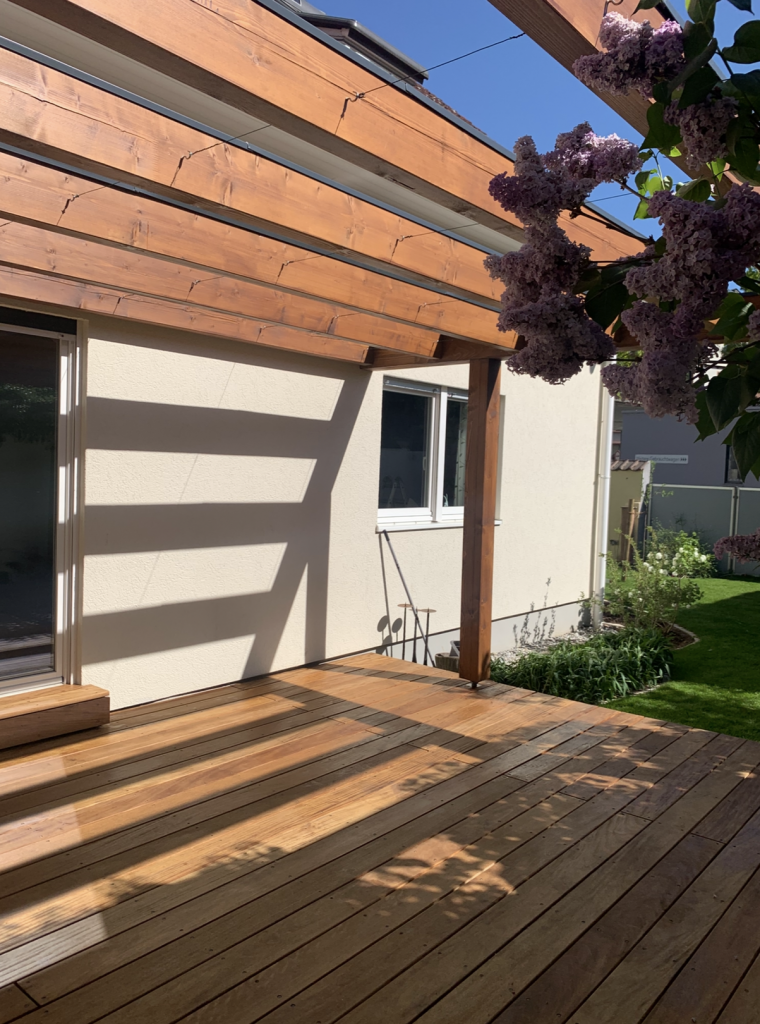 Neue Garapa-Holzterrasse mit maßgefertigter Pergola und stimmungsvollen Lichtschatten in einem Garten in Frankfurt-Fechenheim