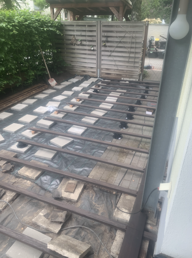 Vorbereitete Unterkonstruktion für den Neubau einer Bambusterrasse in Frankfurt-Bornheim. Sichtbar sind Stelzlager, Auflageplatten und die ausgerichteten Tragbalken vor der Dielenverlegung.
