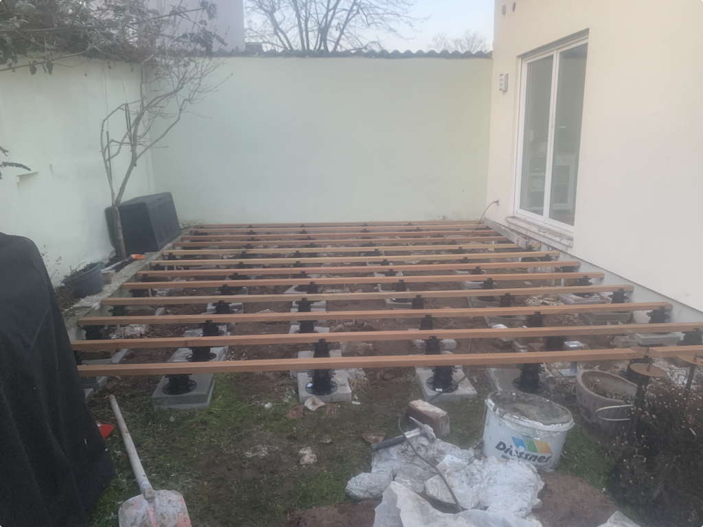 Montage der Terrassenunterkonstruktion mit höhenverstellbaren Stelzlagern für eine neue Garapa-Holzterrasse in Frankfurt-Fechenheim vor der Verlegung der Terrassendielen
