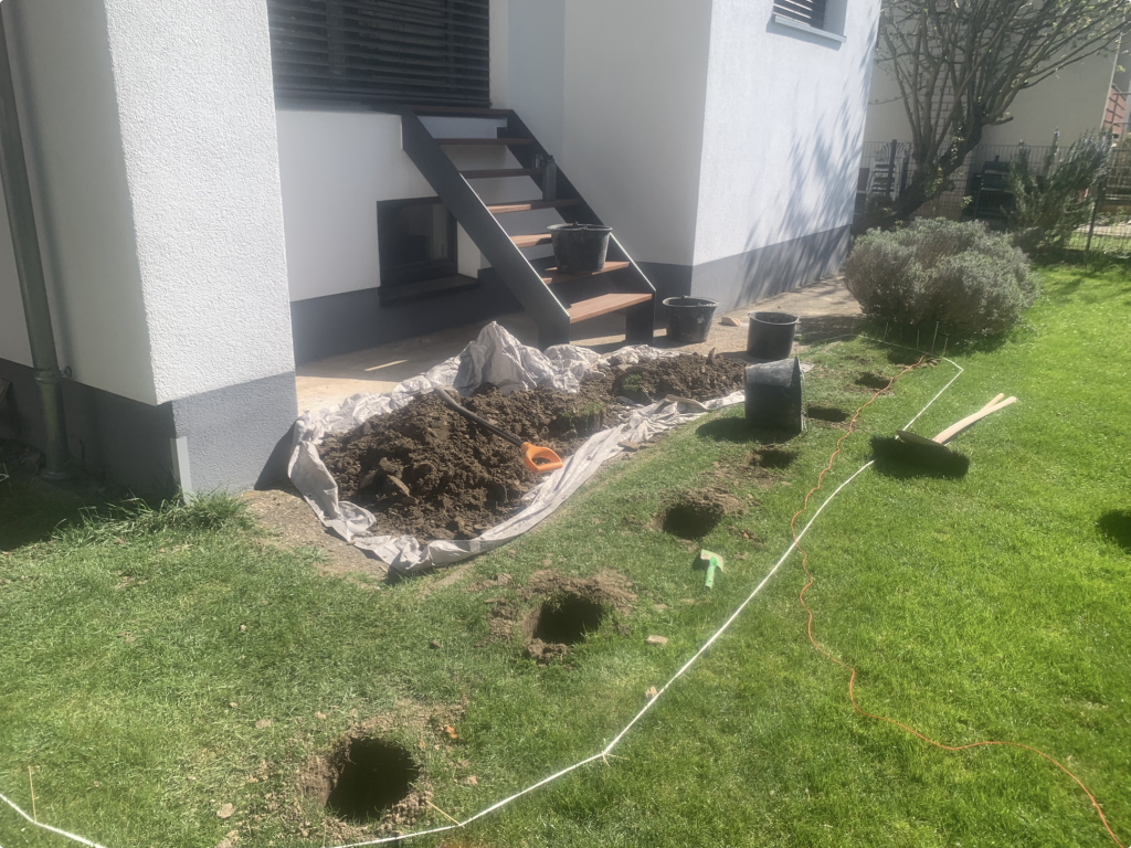 Vorbereitung der Fundamente für eine Bankirai-Terrasse im Raum Frankfurt mit ausgesteckter Terrassenfläche und ausgehobenen Punktfundamenten.
