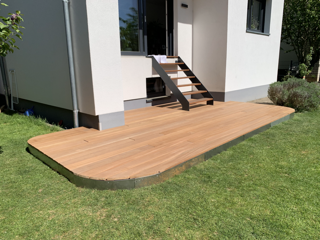 Bankirai-Terrasse mit abgerundeter Vorderkante und bestehender Treppe an einem Einfamilienhaus im Rhein-Main-Gebiet.