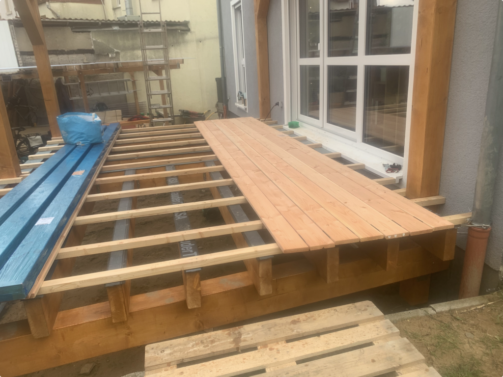 Verlegung von Douglasie-Terrassendielen auf einer stabilen Holzunterkonstruktion.