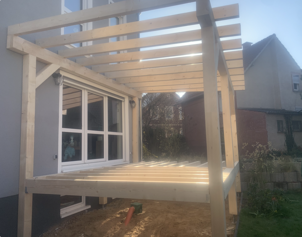 Massive Holzkonstruktion einer erhöhten Holzterrasse mit Terrassenüberdachung während der Bauphase.