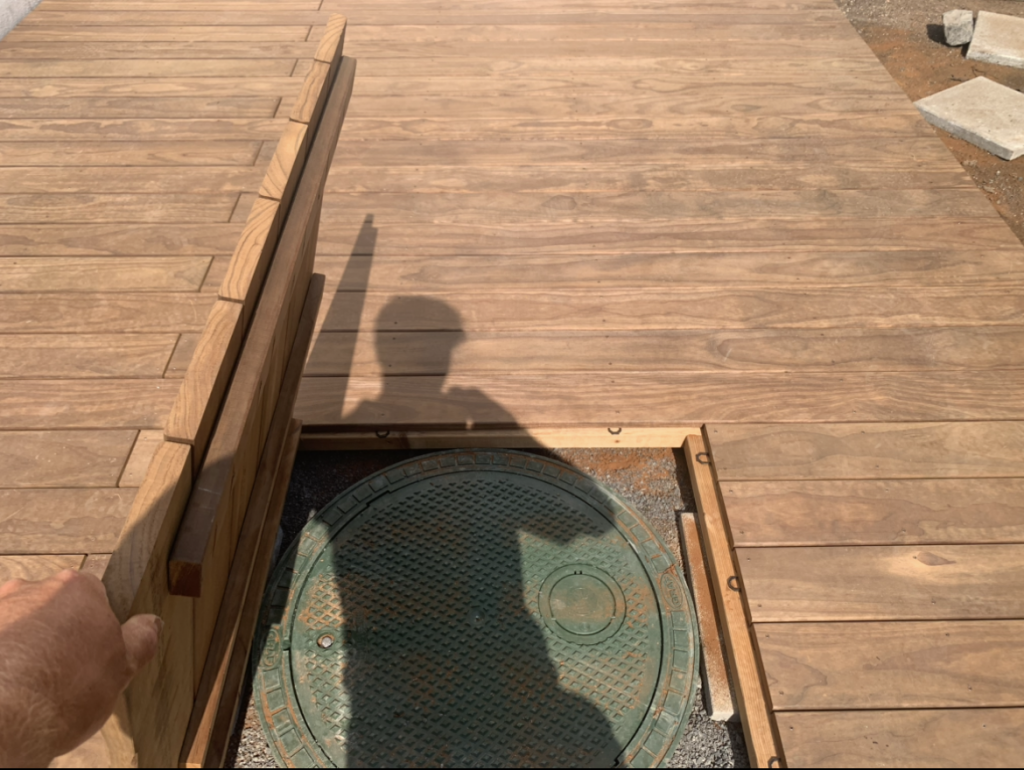 Geöffnete Wartungsklappe einer Kebony-Terrasse über einer Zisterne.
